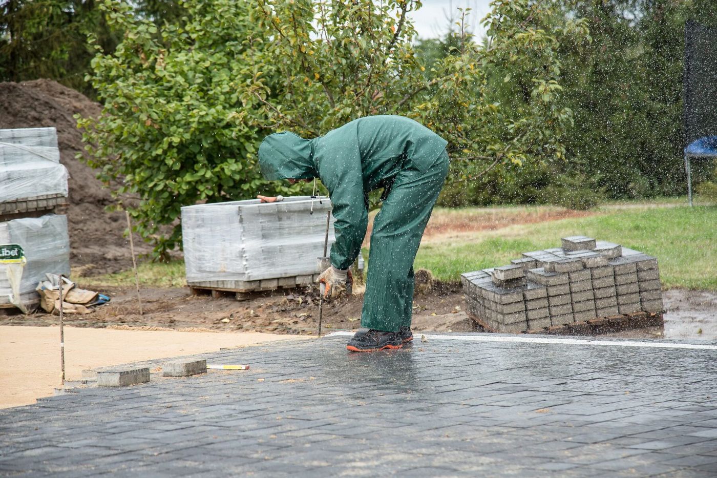 Worker laying pavers on a new patio