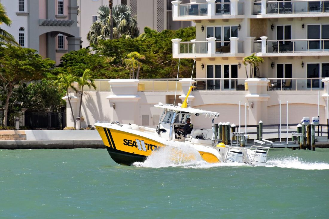 Center-console boat running along a waterfront