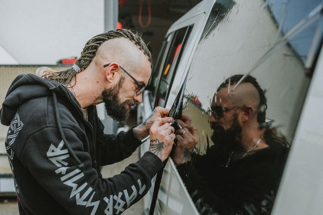 Installer fitting tint film to a car window